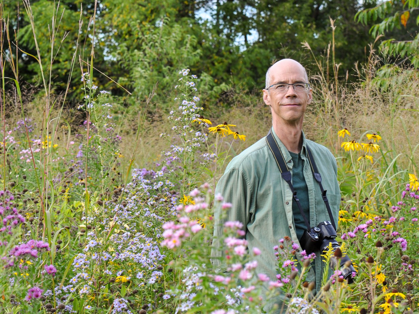 Gary Campbell posing in his meadow with fall blooming color
