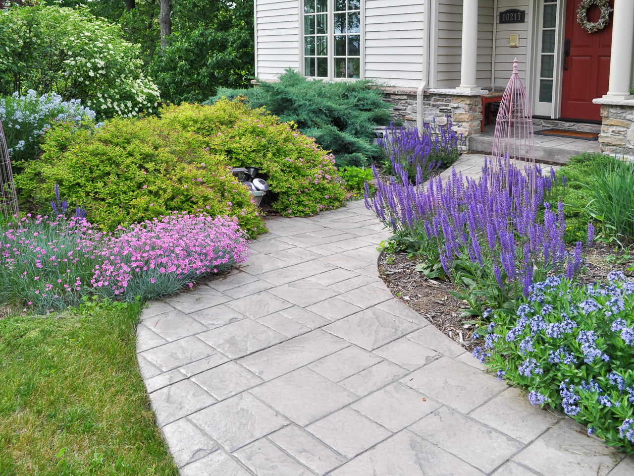 Home entry walk leading to front porch through colorful plantings