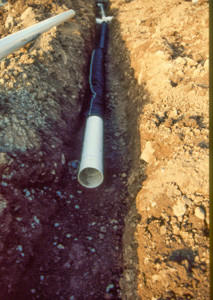 Perforated drain pipe being buried